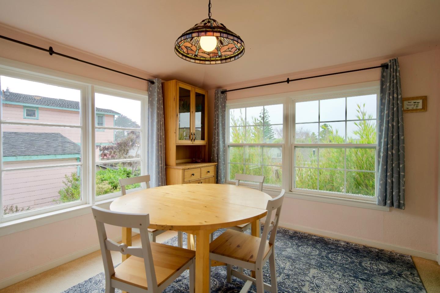390 Pacific Avenue Pacifica, CA 94044 - Photo 11 of 24 a view of a dining room with furniture large windows and wooden floor