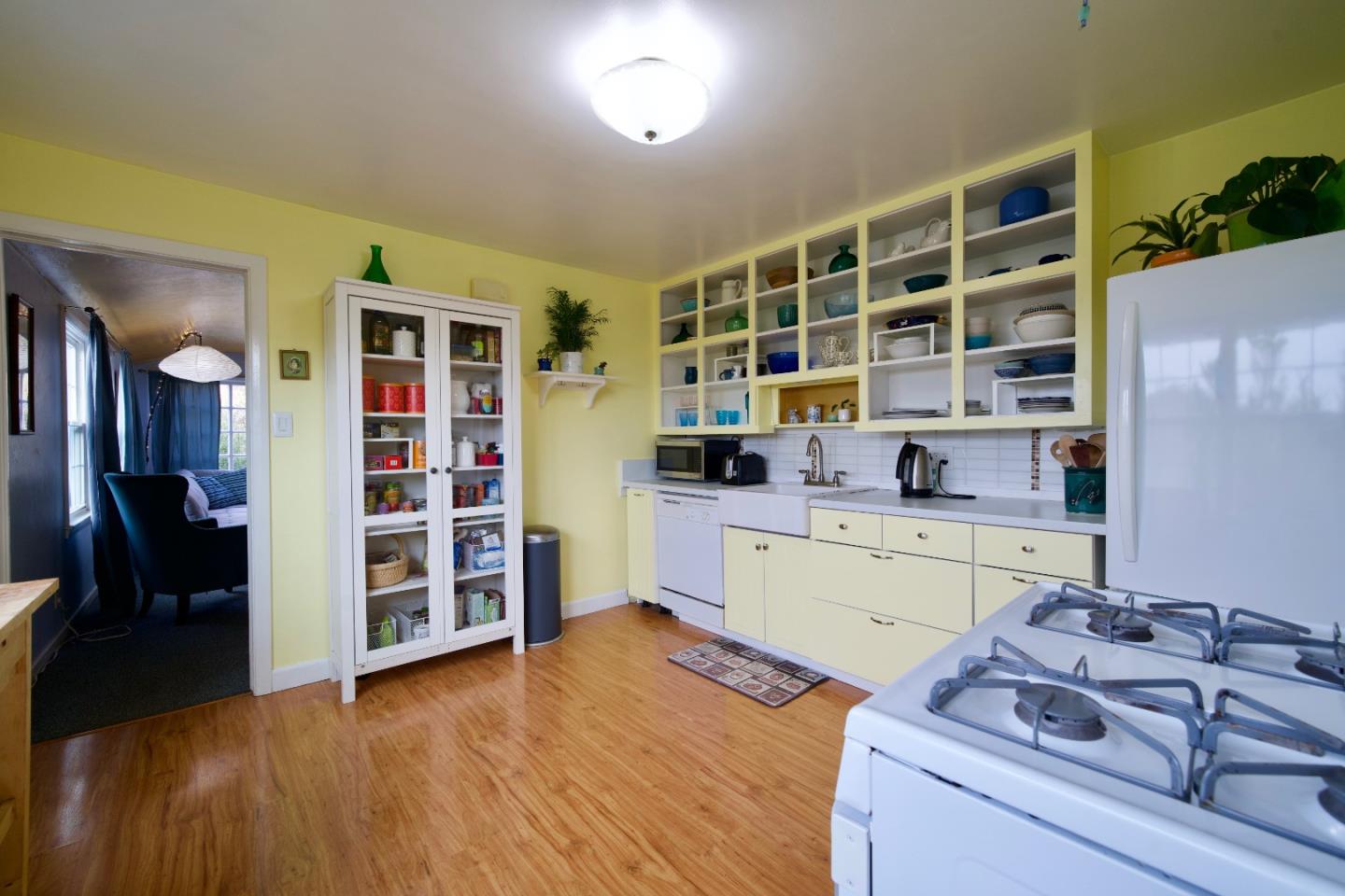 390 Pacific Avenue Pacifica, CA 94044 - Photo 8 of 24 a kitchen with a wooden floor and a large window