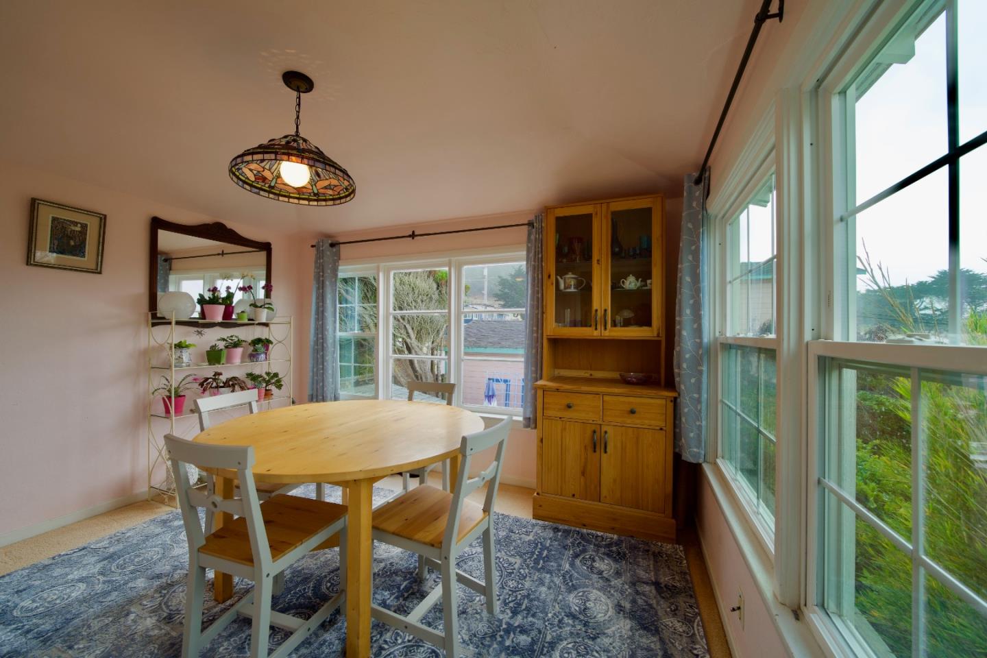 390 Pacific Avenue Pacifica, CA 94044 - Photo 10 of 24 a view of a dining room with furniture large window and wooden floor