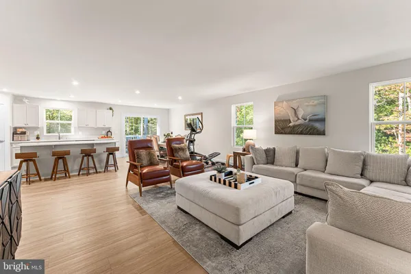 a living room with furniture and view of kitchen
