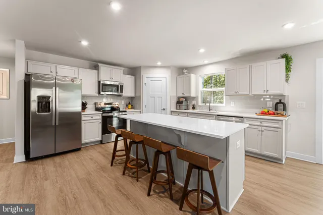 a kitchen with refrigerator cabinets and wooden floor