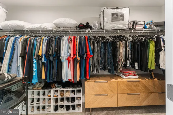 a view of walk in closet with clothes