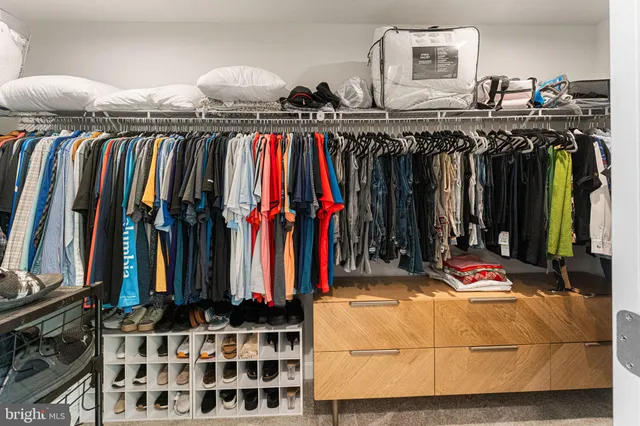a view of walk in closet with clothes
