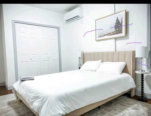 a bedroom with a bed and a painting on the wall