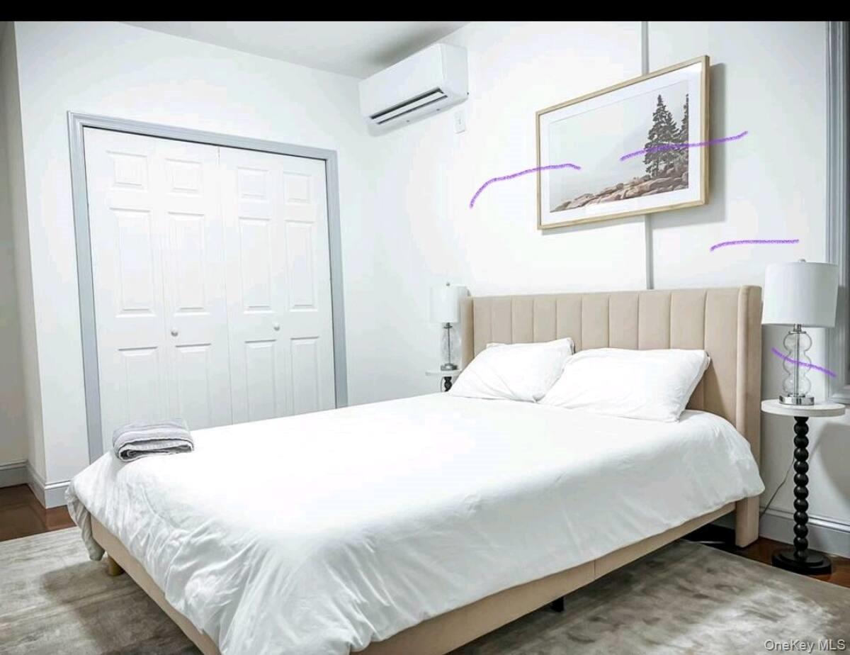 188-25 Keeseville Avenue, Unit 1 Queens, NY 11412 - Photo 5 of 8 a bedroom with a bed and a painting on the wall