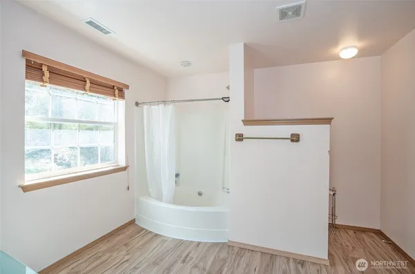 a bathroom with a bathtub and a window