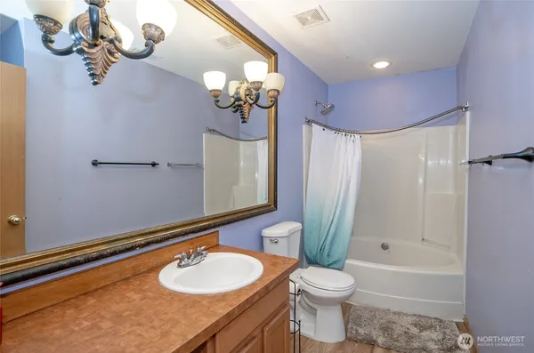 a bathroom with a granite countertop sink a toilet and a bathtub