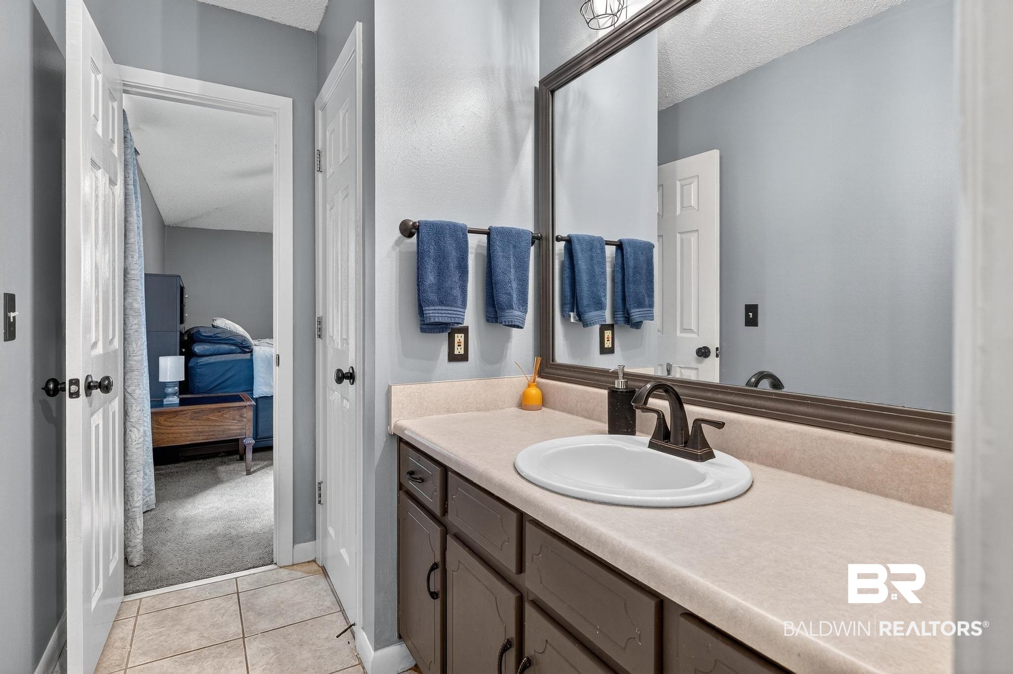 21895 2nd Street Silverhill, AL 36576 - Photo 32 of 43 Primary bathroom featuring light tile floors, vanity, and ensuite bathroom
