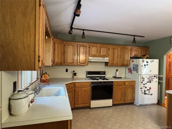 a kitchen with stainless steel appliances a stove a sink and white cabinets