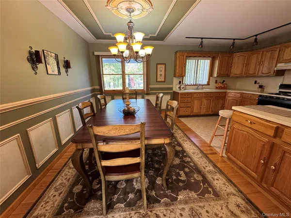 a view of a dining room with furniture a chandelier and wooden floor
