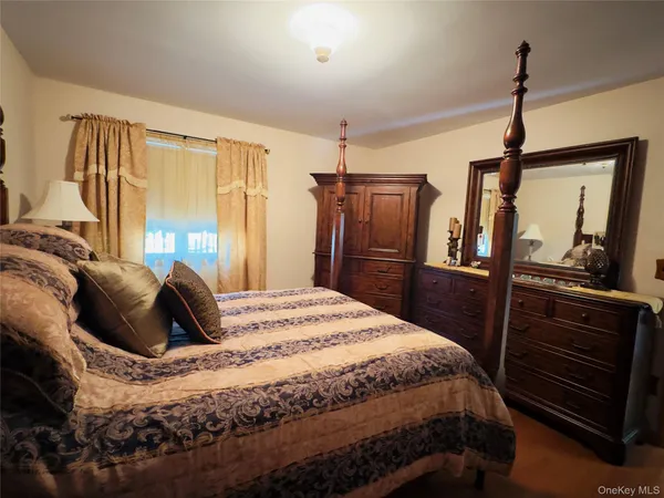 a bedroom with a bed a dresser and large mirror