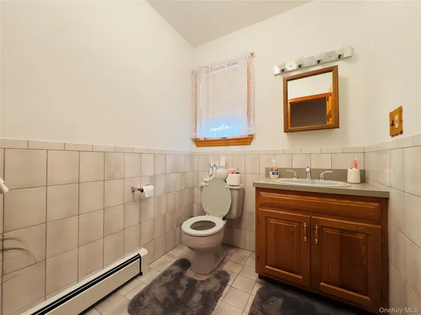 a bathroom with a granite countertop toilet sink and mirror