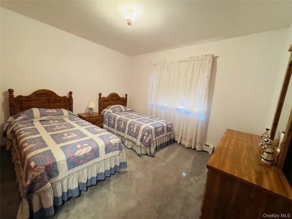 a bedroom with two beds and wooden floor