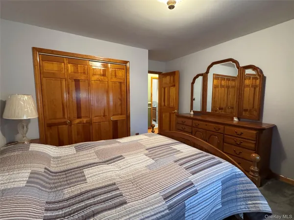 a bedroom with a bed a dresser and mirror