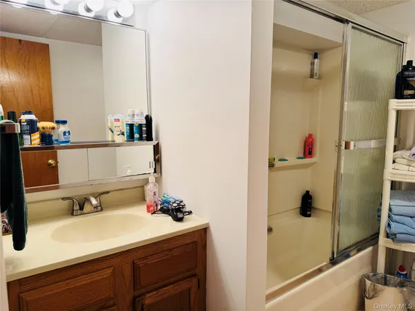 a bathroom with a tub sink and mirror
