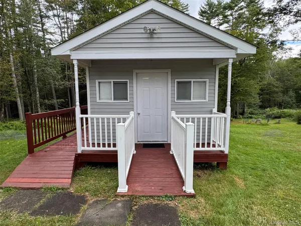 a view of a house with a yard and deck