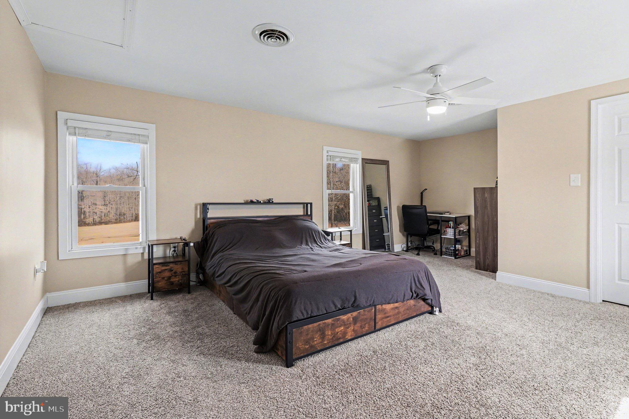 5408 Lewiston Road Spotsylvania, VA 22551 - Photo 11 of 32 a bedroom with a large bed and a chandelier