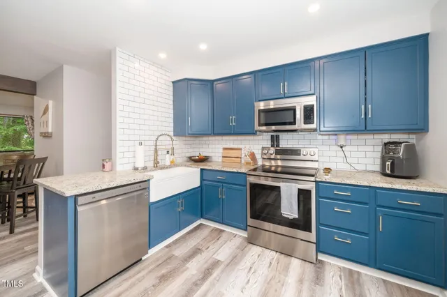 a kitchen with granite countertop wooden cabinets stainless steel appliances and a window
