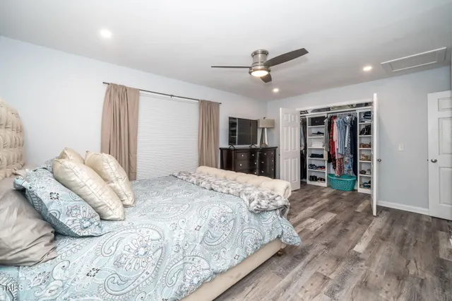 a spacious bedroom with a bed and a large mirror