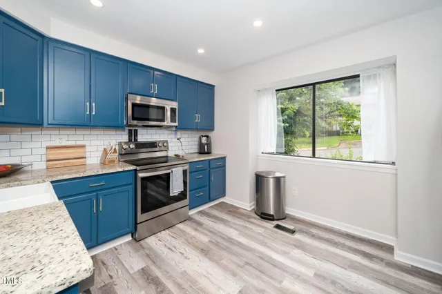 a kitchen with a stove a microwave and a sink