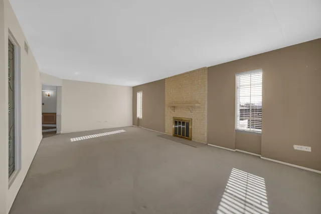 a view of an empty room with cabinet and a window