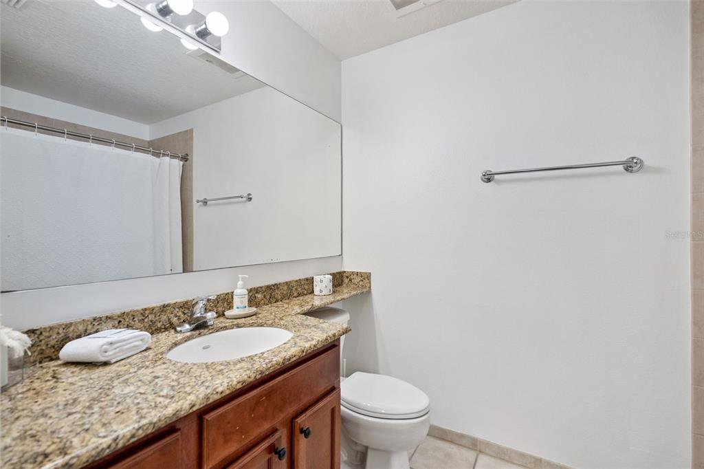 8762 Worldquest Boulevard, Unit 5103 Orlando, FL 32821 - Photo 15 of 30 a bathroom with a granite countertop sink and a mirror