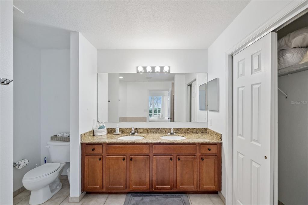 8762 Worldquest Boulevard, Unit 5103 Orlando, FL 32821 - Photo 16 of 30 a bathroom with a granite countertop sink and a mirror