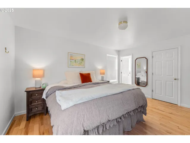 a bedroom with a bed and a dresser with mirror