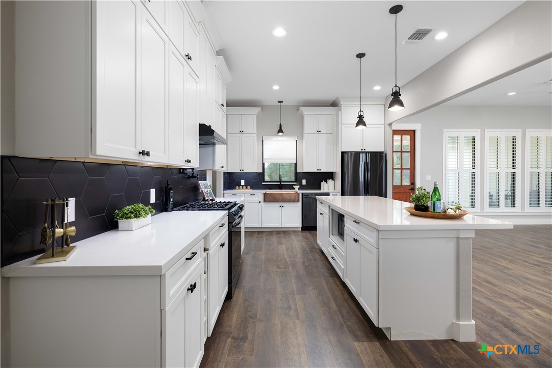 537 Compass Rose Spring Branch, TX 78070 - Photo 7 of 29 a large kitchen with stainless steel appliances kitchen island a large counter top and a stove