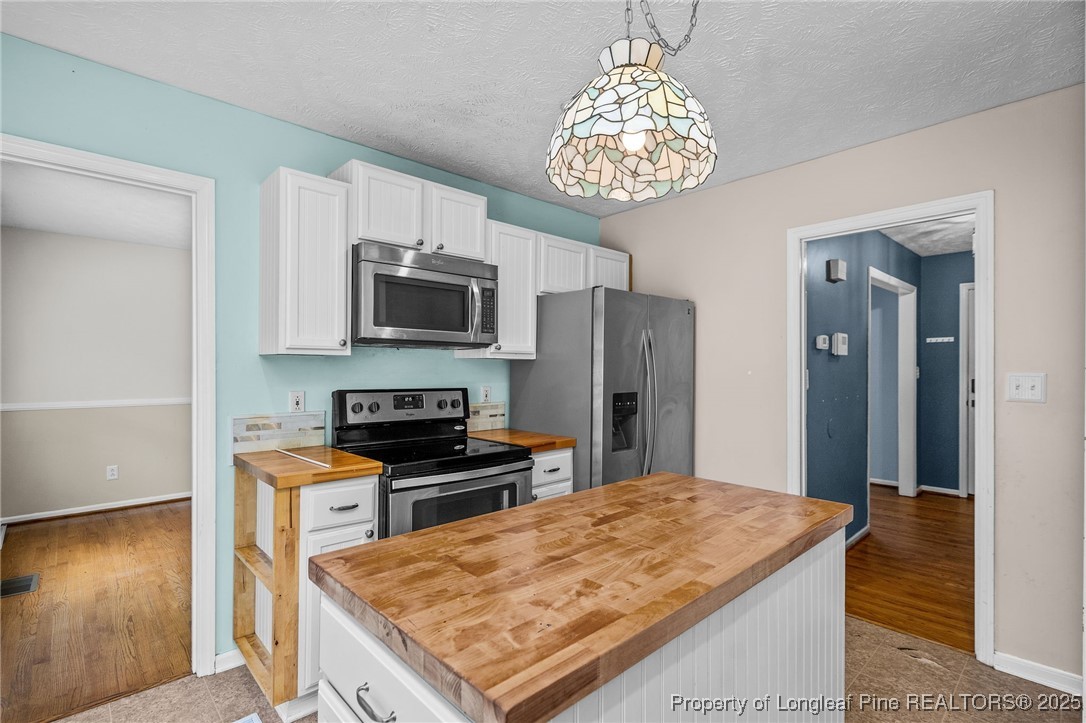 8810 Tangletree Drive Linden, NC 28356 - Photo 16 of 50 a kitchen with stainless steel appliances granite countertop a sink stove and refrigerator