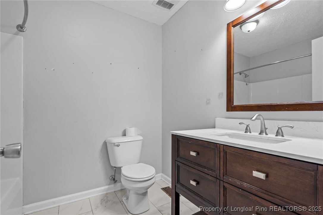 8810 Tangletree Drive Linden, NC 28356 - Photo 29 of 50 a bathroom with a toilet sink vanity and mirror