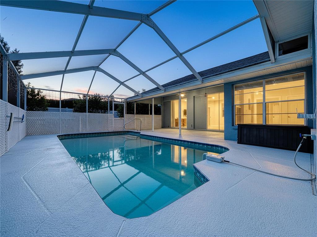 18812 Bascomb Lane Hudson, FL 34667 - Photo 9 of 57 a view of a swimming pool with a chair and table in the back yard