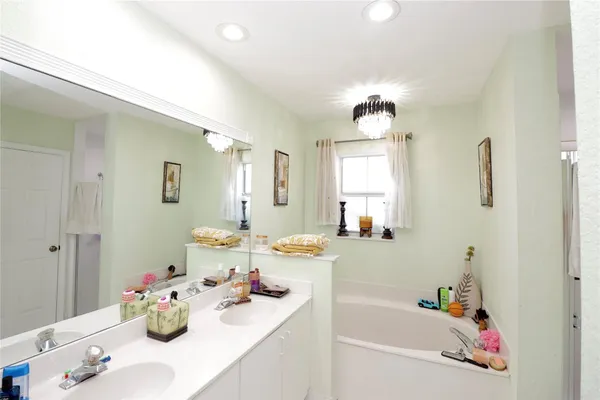 a bathroom with a sink mirror and a bathtub