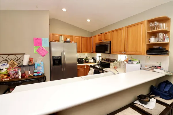 a kitchen with stainless steel appliances granite countertop a sink refrigerator and microwave