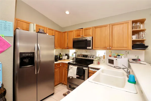 a kitchen with stainless steel appliances cabinets a microwave a sink and a refrigerator