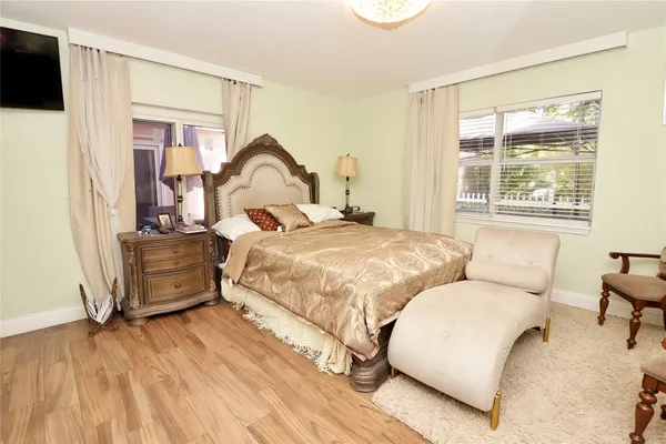a bedroom with a bed and a flat tv screen on the dresser