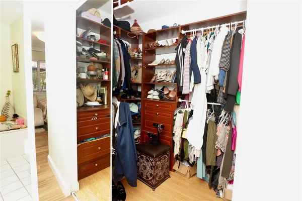a view of walk in closet with clothes and shoes