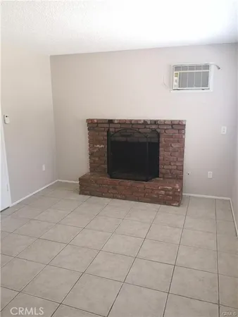 a view of a livingroom with an empty space and a fireplace