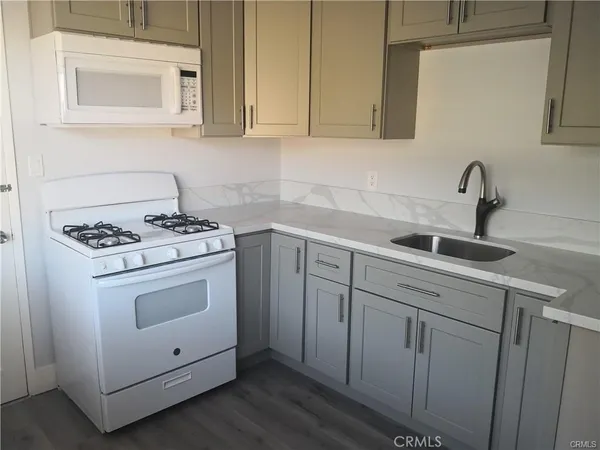 a kitchen with white cabinets and sink