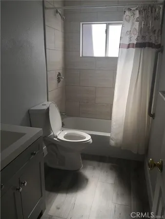 a white toilet sitting next to a bathroom sink and vanity