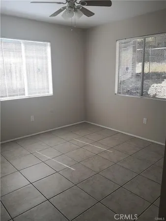 an empty room with a fan & a window