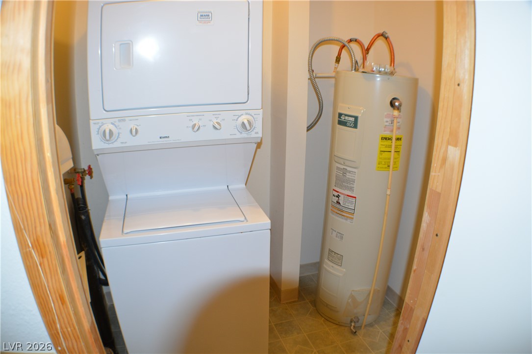 1321 Trout Canyon Road Las Vegas, NV 89124 - Photo 45 of 50 A dedicated laundry space featuring a stacked washer and dryer, alongside an efficient water heater.