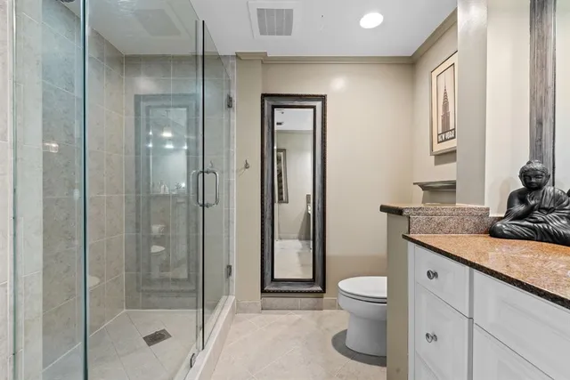 a bathroom with a granite countertop sink a toilet and shower