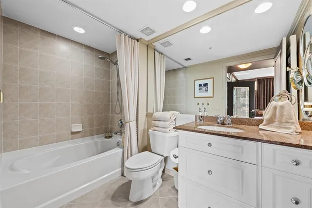 a bathroom with a granite countertop sink a toilet a mirror and shower