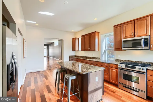 a kitchen with stainless steel appliances granite countertop a stove and a refrigerator