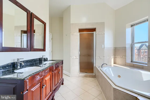 a bathroom with a granite countertop tub sink and mirror