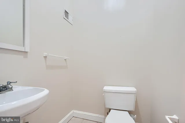 a white toilet sitting next to a white sink and vanity