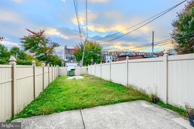 a view of a backyard with wooden fence