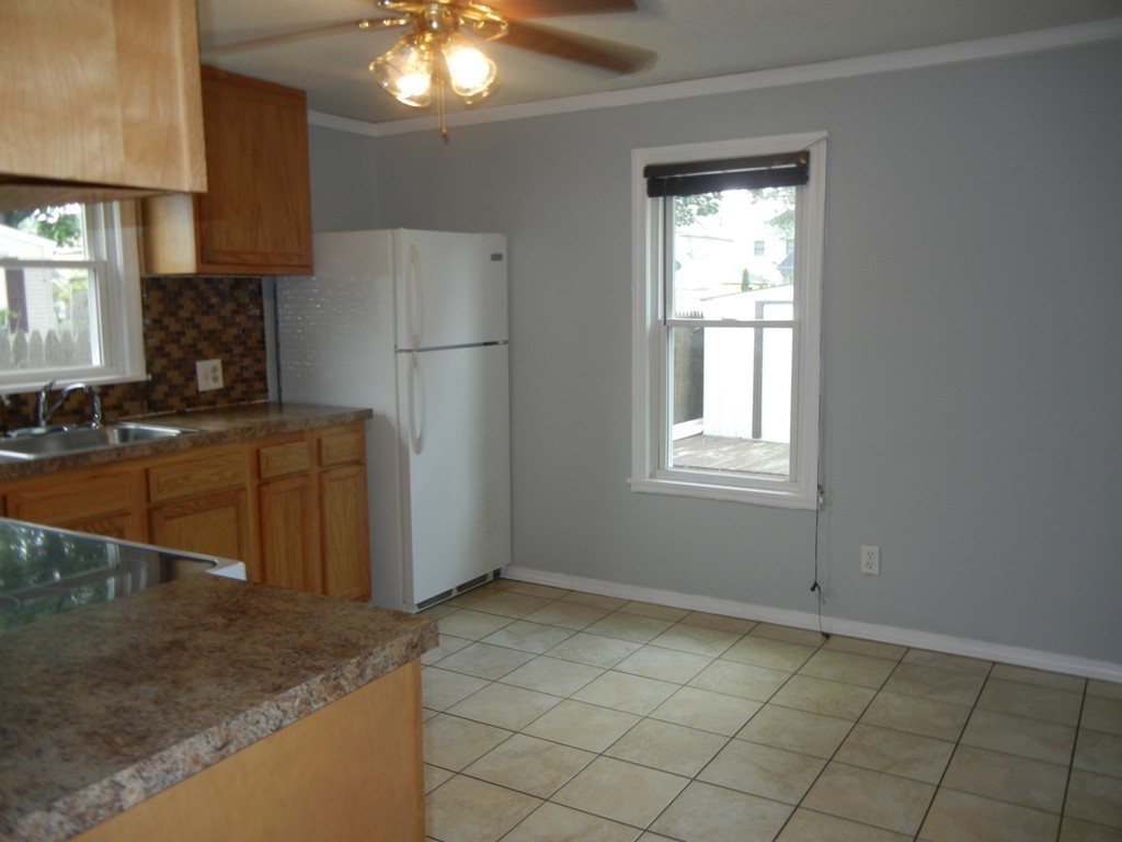 141 Freeman Terrace Springfield, MA 01104 - Photo 7 of 21 a kitchen with a sink a refrigerator and cabinets