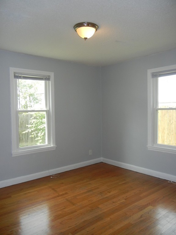 141 Freeman Terrace Springfield, MA 01104 - Photo 9 of 21 an empty room with wooden floor and windows